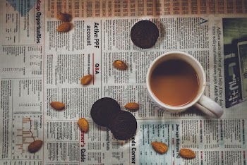 White Ceramic Mug on Newspaper