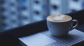 white ceramic mug with designed cappuccino