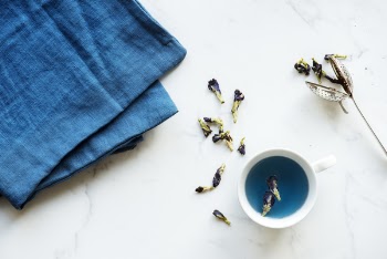 White Ceramic Teacup Near Blue Textile