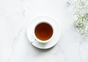 White Ceramic Teacup on Saucer With Brown Liquid