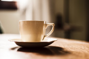White Ceramic Teacup With Saucer on Wooden Table
