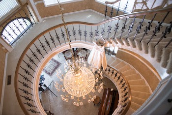White Chandelier Between Gray and Brown Swirl Stair