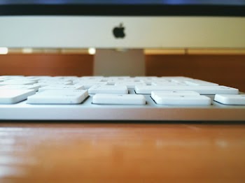 White Computer Keyboard on Brown Wooden Table