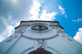 White Concrete Building With Clock Under Blue White Sky