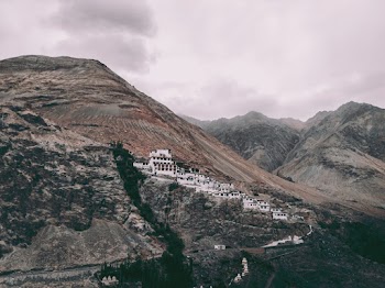 White Concrete Buildings on Rock Mountain Under Gray Sky