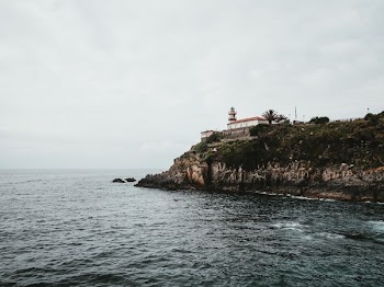 white concrete house on cliff at daytime