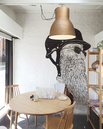 White Concrete Wall With Portrait of a Man With Beard and Black Helmet