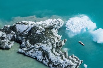 white cruise ship passing by white and grey island