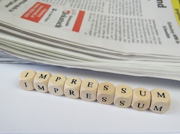 White Dice Beside Newspaper