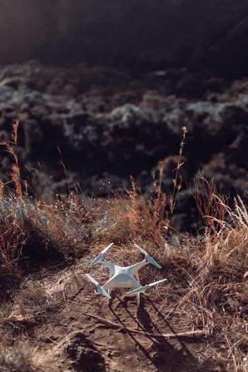White Drone Quad Copter On Grass Field