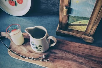 White Floral Ceramic Pitcher Beside Clear Drinking Glass