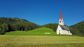 White Gray and Red Chapel on Green Field during Clear Sky Day Time