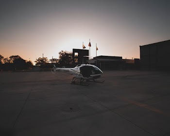 White Helicopter Across Three Flag Poles