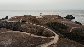 white house on mountain cliff near shore