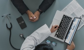 White Laptop Computer Beside Person in Black Suit