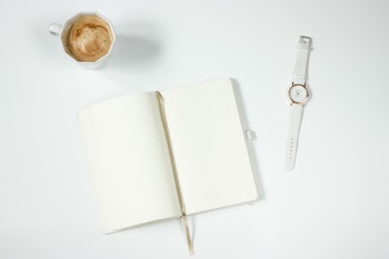 White Leather Strap Silver Round Analog Watch Next to Notebook