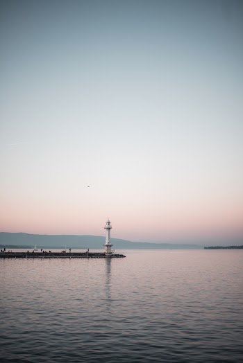 White Lighthouse Beside Body Of Water