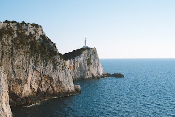 White Lighthouse on Top of Cliff in Beach
