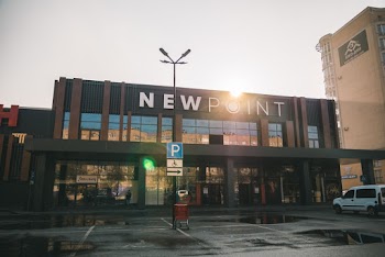 White Minivan Parked in Front of New Point Building