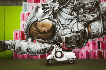 White Motor Scooter Parked Near Graffiti Wall