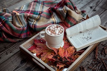 white open book near white ceramic cup