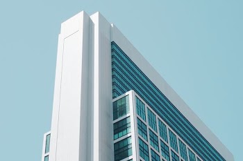 white painted building with blue glass mirror window