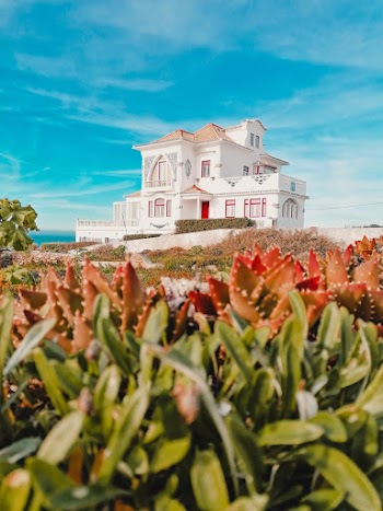 White Painted House Surrounded With Grass Field