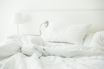White pillow on rumpled bed
