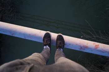 White Pipe Above Green Body of Water during Daytime