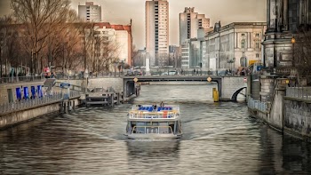 White Powerboat Under Gray Bridge