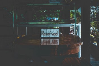 White Reserved Sign on Brown Wooden Table