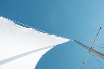 white sails on boat mast under clear sky during daytime