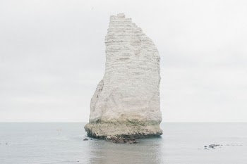 white stone formation in the middle of the sea