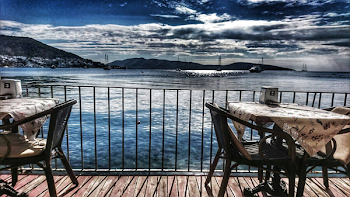 White Table With Two Armchair Set Near Body of Water and Mountain