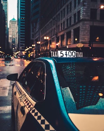 white taxi passing on road