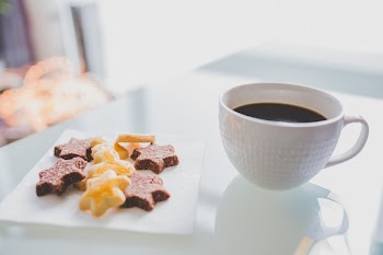 White Tea Cup Beside White Square Saucer With Star Shaped Cookies
