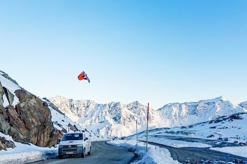 white vehicle on roadway near mountain covered by snow at daytime