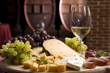 White wine in fine glass with cheese and grape