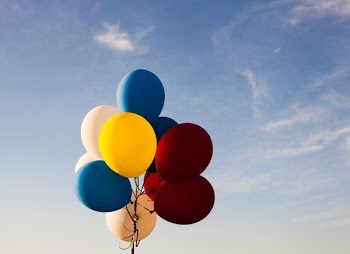 white, yellow, red, and blue balloons under blue sky