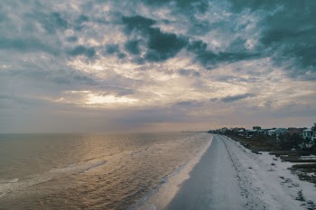 Wide Angle Photo of Shore Under Cloudy Sky