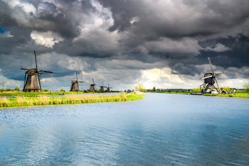 Wind Mills Near Body of Water