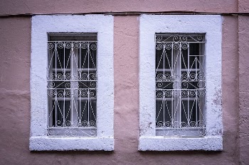 Windows with Metal Railings on Pink Concrete Wall