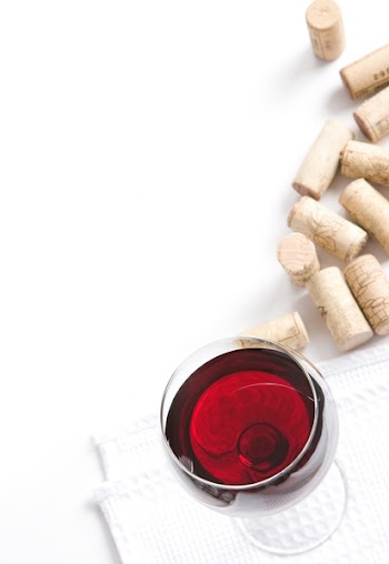 Winery menu project. Various corks and glass filled with red wine. Space for text isolated on white.