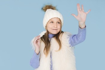 Winter dressed little girl raising her hand Free Photo