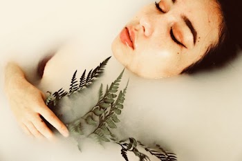 Woman's Body Submerged In Water Holding Green Plant