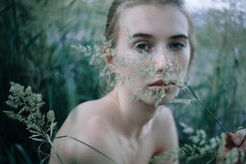 Woman's Face Behind Green Plant