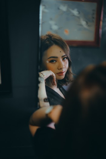 Woman's Reflection On A Mirror