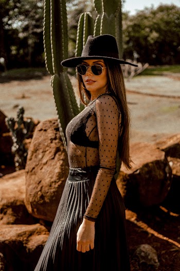 Woman a Black Hat Standing Near a Cactus Plant