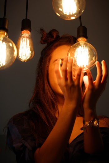Woman About to Hold Edison Light Bulb