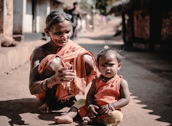 Woman and a Child Sitting on Concrete Road